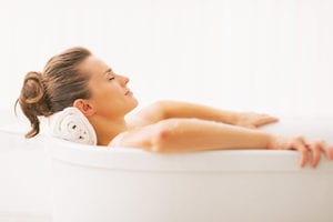 photo of a woman in a bath using a cbd infused topical product