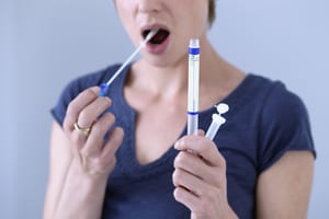 image shows a woman doing a saliva swab drug test