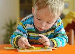 a photo of a boy toddler doing a puzzle to go along with the paragraph detailing the long-term effects of marijuana if a pregnant person uses