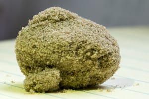 a close-up photo of a big ball of kief sitting on a table
