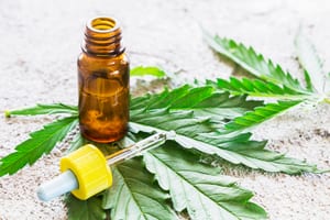 photo of marijuana tincture placed on top of a marijuana leaf