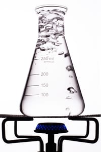 image of a flask with boiling liquid in it sitting over a burner