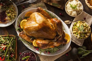 image of a turkey for thanksgiving with mashed potatoes, green beans, and stuffing next to it