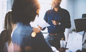 image of a professional workplace meeting with sun coming through the window, everyone is dressed professionally