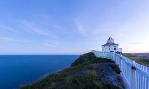 image of a house on the water in newfoundland with a beautiful sky behind it