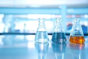 image of multiple flasks with different liquids in a laboratory