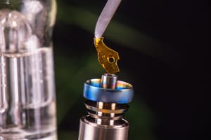 image of a dab being held over a dab rig, ready to be consumed
